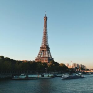 Scenic view of the Eiffel Tower and Seine River at sunset, showcasing iconic Parisian architecture.